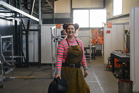 一名持有头盔和准备在金属工业工作日的妇女焊接商的肖像以及工厂职业工程工具技术员练习艺术质量服务机械图片