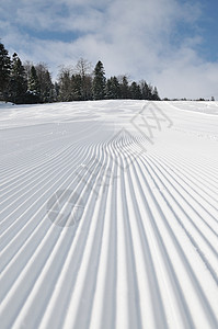 在美丽的阳光明媚的冬日 滑雪斜坡上的脚印越野蓝色运动路线小路爬坡滑雪者车削娱乐途径图片