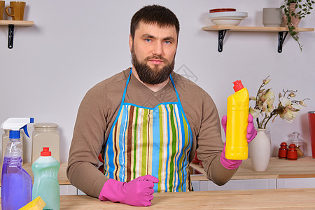 厨房的英俊长胡子男 用洗涤剂 刷子 喷雾器打扫干净看门人家政房子手套橡皮家务抹布化学品工作卫生图片