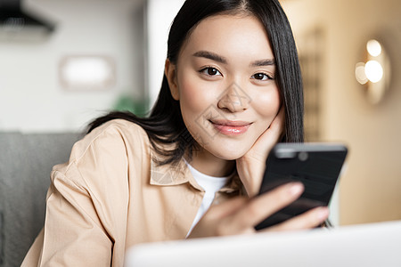 在家用笔记本电脑工作 看智能手机的笑容女性口罩女孩上网会议学生班级教育研讨会互联网乐趣图片