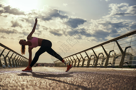 上午锻炼 在运动服上做瑜伽练习时站在桥上 身穿假腿的残疾青年妇女全年从事体操图片