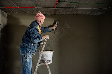 工人用混凝土在墙上打石膏建筑房子安全贸易脚手架建筑学男人高度维修泥水匠图片