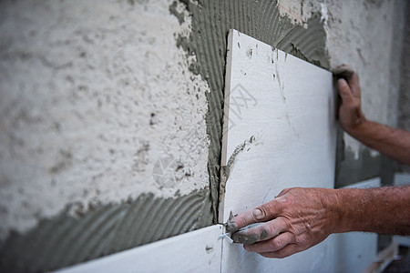 安装大瓷砖的工人工作房子工匠装修正方形平铺石膏材料技术制品图片