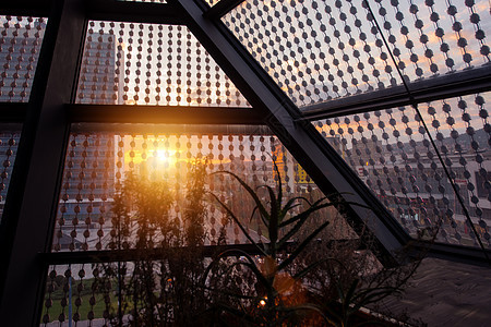 日落在玻璃屋顶上钟楼窗户商业房子城市反思建造蓝色太阳天空图片