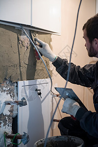 工人用混凝土在墙上打石膏装修石膏板高度男人石工房子职业材料建筑学水泥图片