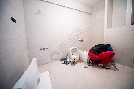 在卫生间工作的专业水管工管道修理工扳手男性淋浴房子脸盆洗手间安装建筑图片