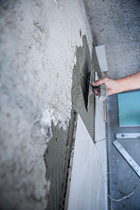 安装大瓷砖的工人维修住宅正方形制品建设者陶瓷墙壁平铺石膏工作图片