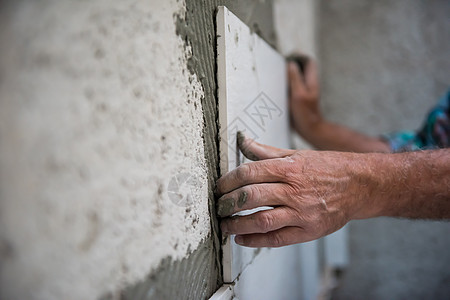 安装大瓷砖的工人墙壁公寓陶瓷平铺石膏地面建设者工作正方形工具背景图片