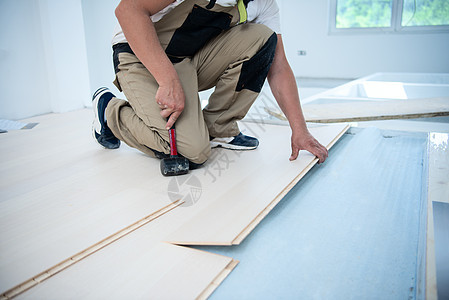 职业工人安装新拉化木制楼层工作木头木工锤子木地板房间男性层压压板硬木控制板图片