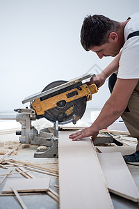 男子用电环锯锯切割压板地板木板木地板工具地面建筑装修锤子测量层压木工安装图片