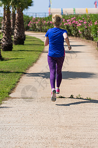 参加马拉松比赛的年轻女青年选手培训热带公园慢跑者棕榈活动女孩衣服活力训练赛跑者图片