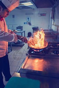 厨师在食物上做烧烤烹饪燃烧行动厨房餐厅餐饮炊具职业酒店美食图片