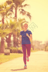 参加马拉松比赛的年轻女青年选手培训女士赛跑者女孩棕榈衣服运动员阳光训练森林运动图片