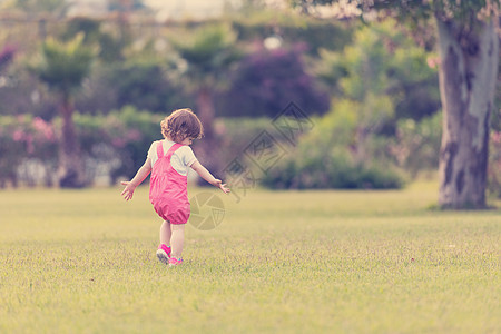 孩子奔跑小女孩在后院花时间女性童年孩子开支快乐院子家庭跑步女孩公园背景