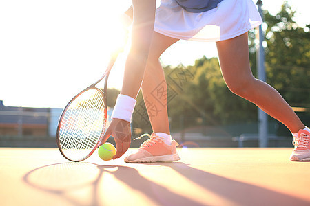 网球员在比赛期间从粘土场里举起一个网球成人阳光球拍活动运动员游戏草地蓝色法庭娱乐图片