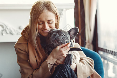 穿着黑色斗牛犬棕色大衣的优雅女人衣服哺乳动物小狗潮人动物女孩友谊女士成人城市图片