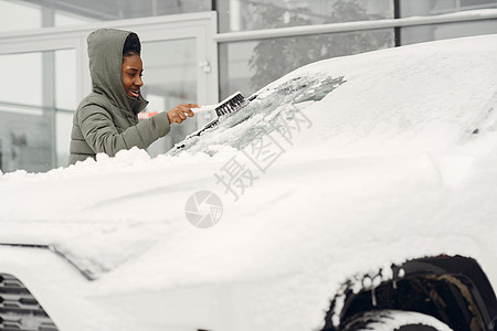 妇女从汽车挡风玻璃上除雪司机夹克窗户暴风雪刷子冻结车辆玻璃降雪刮刀图片