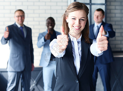 经营理念-有吸引力的女商务人士与团队在办公室竖起大拇指图片
