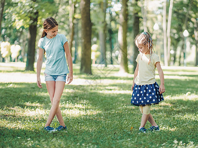 在外边进行芭蕾训练的女生幸福公园友谊闺蜜孩子童年家庭姐姐运动绿色图片