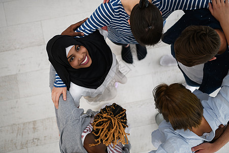 众不同人群的顶端观感 站在一旁拥抱并象征着团结微笑种族朋友们青年圆圈多样性友谊关系学生女孩图片