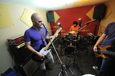 音乐乐队在车库接受培训岩石训练快乐乐器男孩们唱歌吉他手男人麦克风音乐会图片