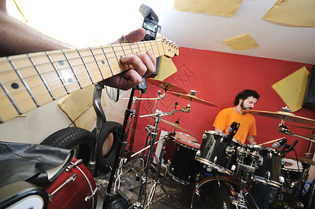 音乐乐队在车库接受培训唱歌团体麦克风男性吉他音乐家男人细绳青年低音图片