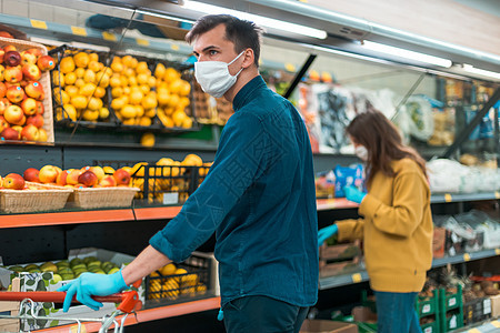 在超市中选择水果的遮面保护型商店店主危险顾客店铺呼吸手套购物者安全感染杂货店危机图片