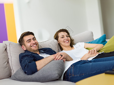 年轻25岁的肖像刚刚结了婚的情侣 在现代工作室公寓的沙发上拍着照片拍摄微笑夫妻互联网女士成人女性技术房间男性男人图片
