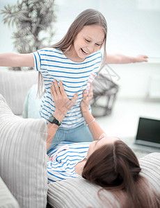 快乐的妈妈和女儿一起玩耍沙发女士成人长椅女性孩子蓝图女孩童年拥抱图片