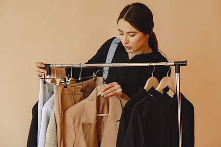 女人在一个工作室 有很多衣服的女人裙子架子衣柜衣架精品女性顾客销售女孩裁缝图片