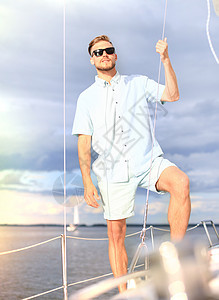 在度假帆船游艇上快乐的放松男人 站在甲板上闲暇太阳镜夫妻女性成人运输男性假期速度运动图片