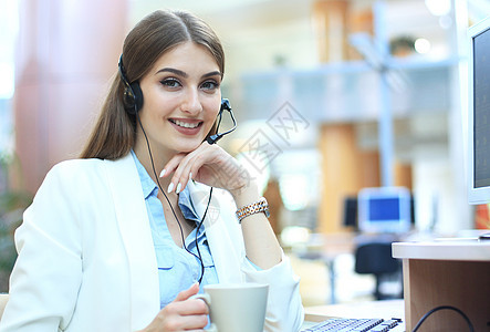 女性客户支持操作员 戴耳贴和微笑推销接待员电话咨询商业顾问代理人服务台服务麦克风图片