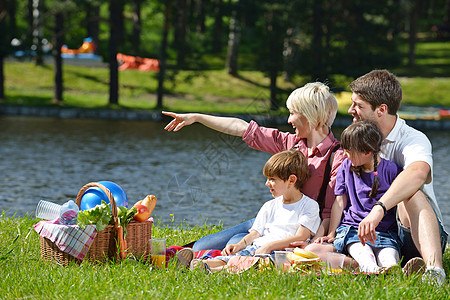 幸福的家庭在野外野餐中一起玩女性团体父亲假期女士成人孩子们公园乐趣食物图片