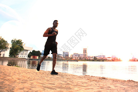 整个非洲青年男子在户外 日落或日出的海滩上运动时 穿着运动服跑步男人动机挑战肌肉城市人士福利护理砖墙体力图片