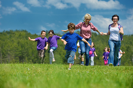 奔跑中的孩子快乐的小孩群体在大自然中玩乐男生团体团队喜悦家庭跑步学校小学生女孩公园背景