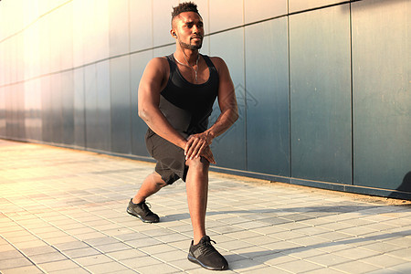 身穿运动服的非洲男子在日落或日出时 在户外升温福利运动体力身体城市护理生活方式体操灵活性男人图片