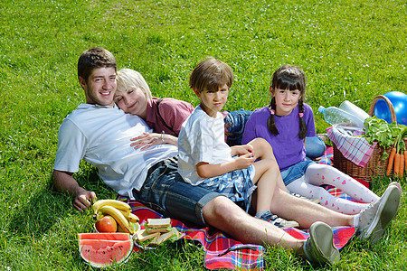 幸福的家庭在野外野餐中一起玩父亲儿子孩子们娱乐午餐成人童年闲暇农村父母图片