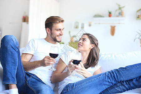 小情侣在起居室喝红酒 喝着一杯红酒房间酒精两个人客厅沙发饮料酒杯微笑女性男性图片