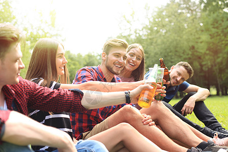 快乐的年轻朋友享受野餐和吃东西友谊派对公司食物阳光旅行男人闲暇乐趣啤酒图片