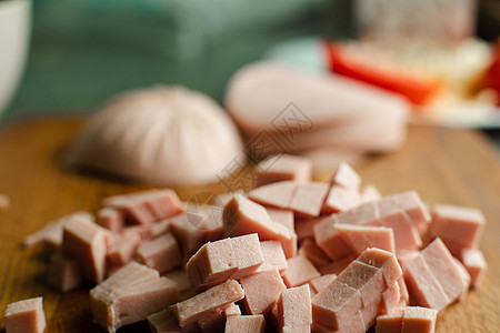 一小堆切片香肠 用来在木制桌上做饭熏制厨房食物木板美食猪肉沙拉烹饪小吃立方体图片