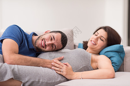 未来的爸爸听着他怀孕妻子的肚子夫妻女士男人父亲母亲婴儿沙发丈夫成人腹部图片