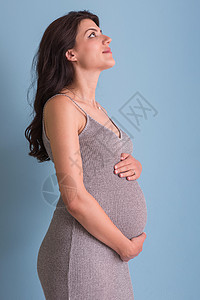 蓝色背景对孕妇的纵向照像快乐工作室怀孕成人女士母性身体女孩女性父母图片