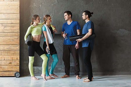 在健身培训前穿运动服装聊天的年轻人 参加体育训练的青年工作室朋友们微笑瑜伽肌肉会议团体身体重量女性图片