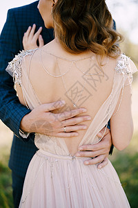 Groom手抱着新娘的后背 后视角 近一点图片