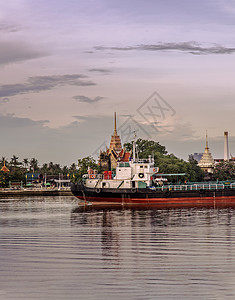 Chao phraya河的景象显示 货船停靠在中河 后面是地区乘客货物血管海洋旅行运输地标天际港口宗教图片