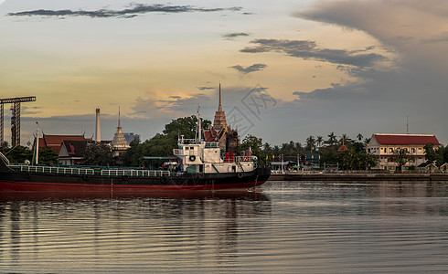 Chao phraya河的景象显示 货船停靠在中河 后面是地区血管天际乘客天空巡航寺庙港口运输旅行海洋图片