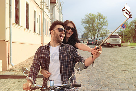 年轻漂亮的夫妇骑着摩托车 冒险和度假的概念 笑声旅行微笑家庭男人假期城市恋人享受世界乐趣图片
