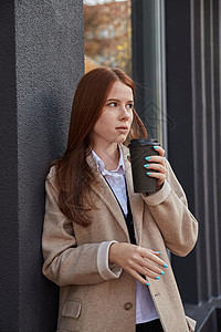 穿着时髦的米花大衣 在室外喝咖啡的年轻美女时间时光窗户外套头发休闲饮料街道公共场所褐色图片