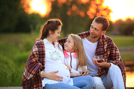 抚养子女的概念     一个幸福的家庭 一无所有女士孩子们野餐阳光父母怀孕喜悦女儿宠物母亲图片