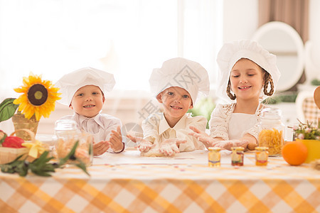 以厨师在厨房做美味早餐的形式 给快乐的小孩们做厨师食物乐趣微笑面团喜悦男生蛋糕家庭女性甜点图片